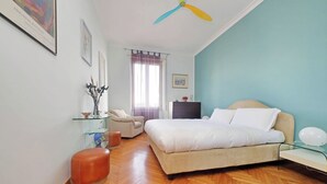 A bedroom with a bed, a chair, a desk, and a ceiling fan. - Una finestra sulla cupola di San Pietro (Rome)