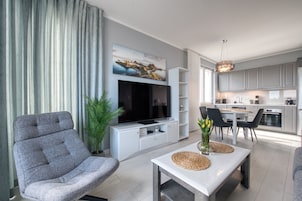 Apartamento Deluxe, balcón | Sala de estar | Una televisión de pantalla plana