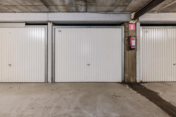 Een parkeergarage met drie witte deuren, genummerd 2055, 2055 en 2057.