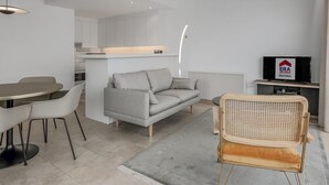 Ein zeitgemäßer Wohnraum mit Essbereich, Sofa und Fernseher.