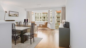 Een modern appartement met een eethoek, een woonkamer en een balkon met uitzicht op de stad.