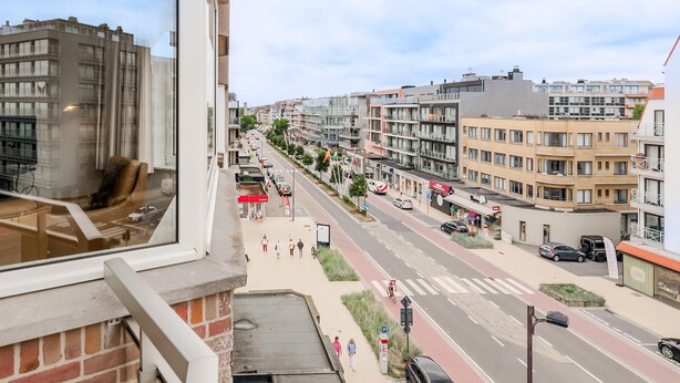 Een stadsstraat met moderne gebouwen, een voetpad en een fietspad.