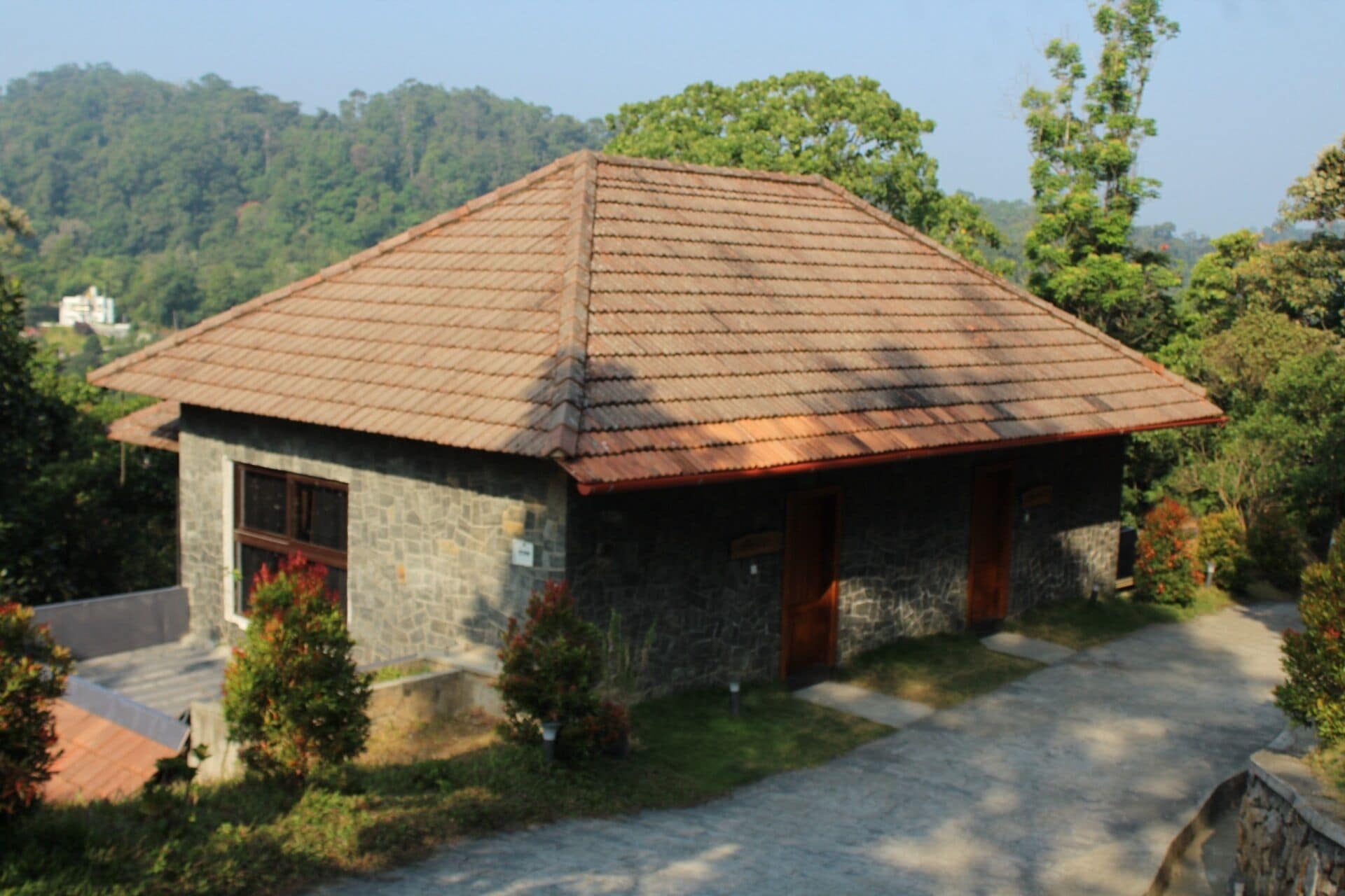 A stone building with a tiled roof, a front door, and a small porch.