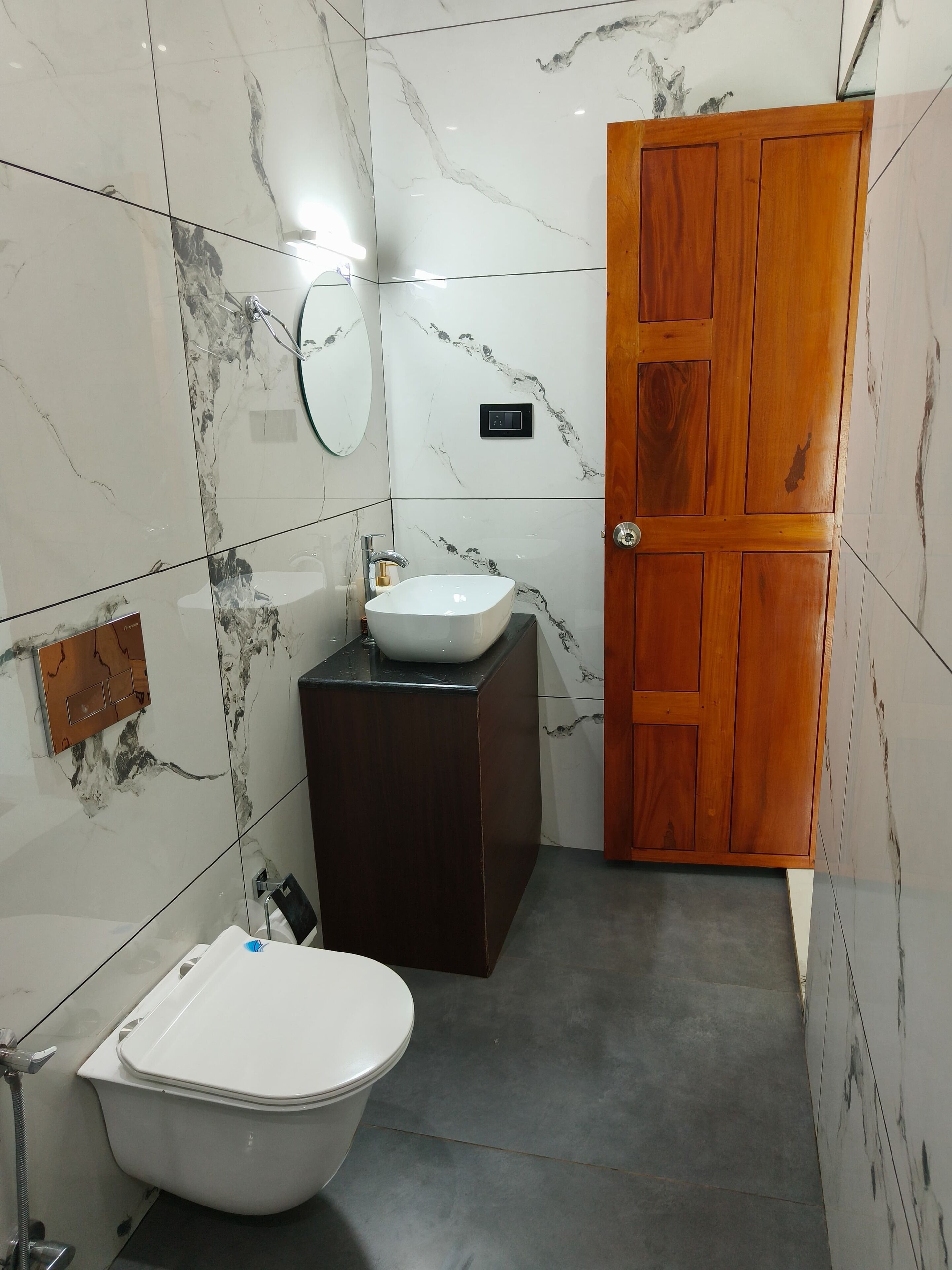 A bathroom with a toilet, sink, and mirror.