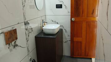 A bathroom with a toilet, sink, and mirror.