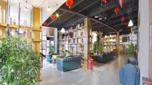 An indoor space with bookshelves, seating areas, and potted plants. - James Joyce Coffetel Beijing Yizhuang East Rongjing Street Metro Station (Beijing)