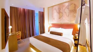A hotel room with a large bed, a desk, a chair, and a world map on the wall. - James Joyce Coffetel Beijing Yizhuang East Rongjing Street Metro Station (Beijing)