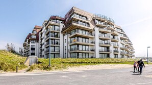 A modern multi-story residential building with balconies, located near a beach. - LONG ISLAND 19, B52 + G (Oostduinkerke)