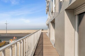 Un balcón con vista a la playa y una torre de salvavidas.