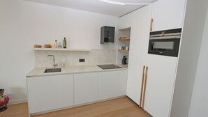 Uma cozinha moderna com forno embutido, pia e bancada.