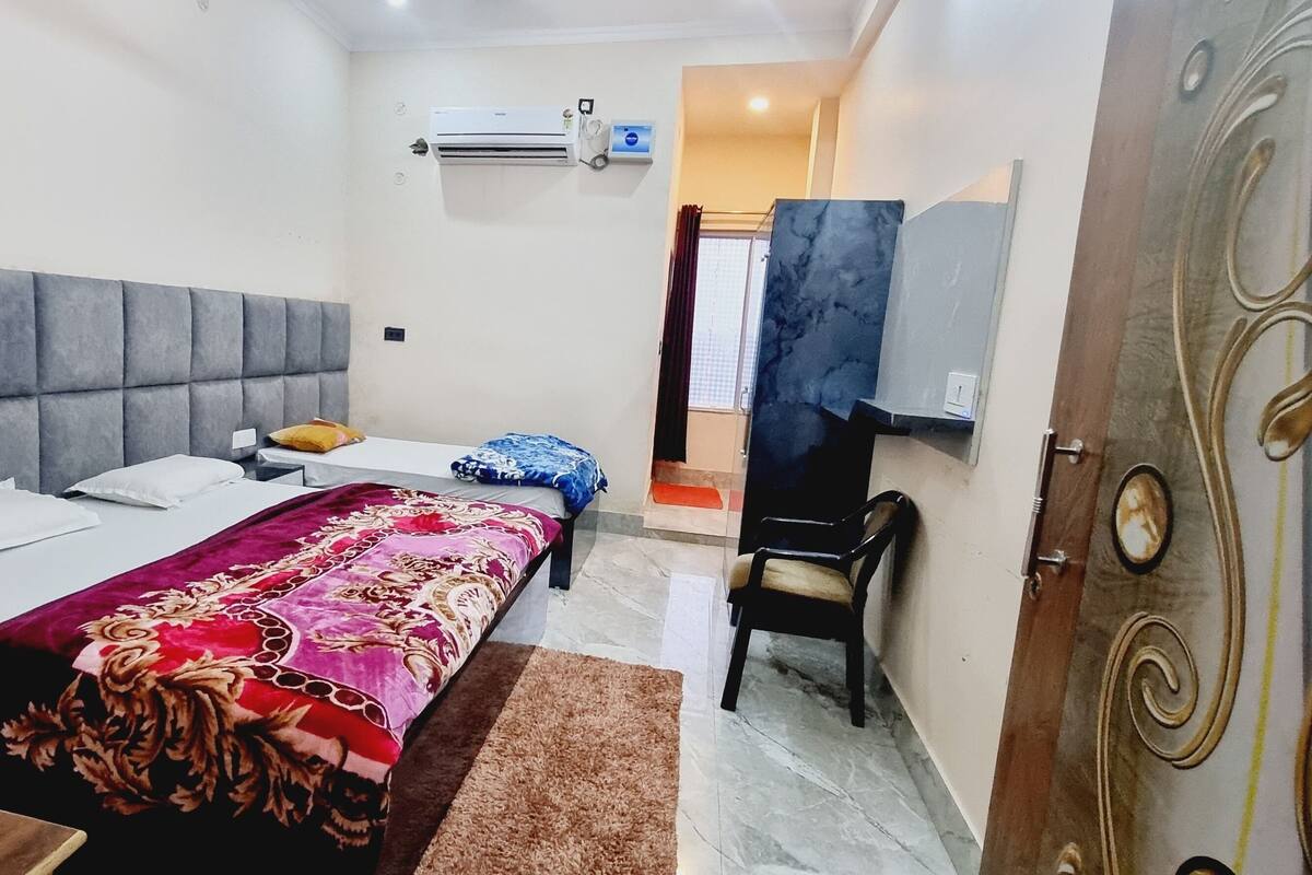 A bedroom with a bed, bedside table, and a chair.