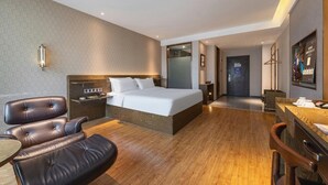 A hotel room with a bed, a desk, a chair, and a bathroom visible through an open door. - James Joyce Coffetel (Chengdu)