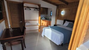 A room with a bed, a desk, a chair, a small kitchenette, and a wooden ceiling. - Room-serene Punta Cana Cabin Retreat - P (Punta Cana)