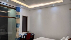 A bedroom with a bed, a desk, and a chair. - Utopia Polhena Hotel (Matara)