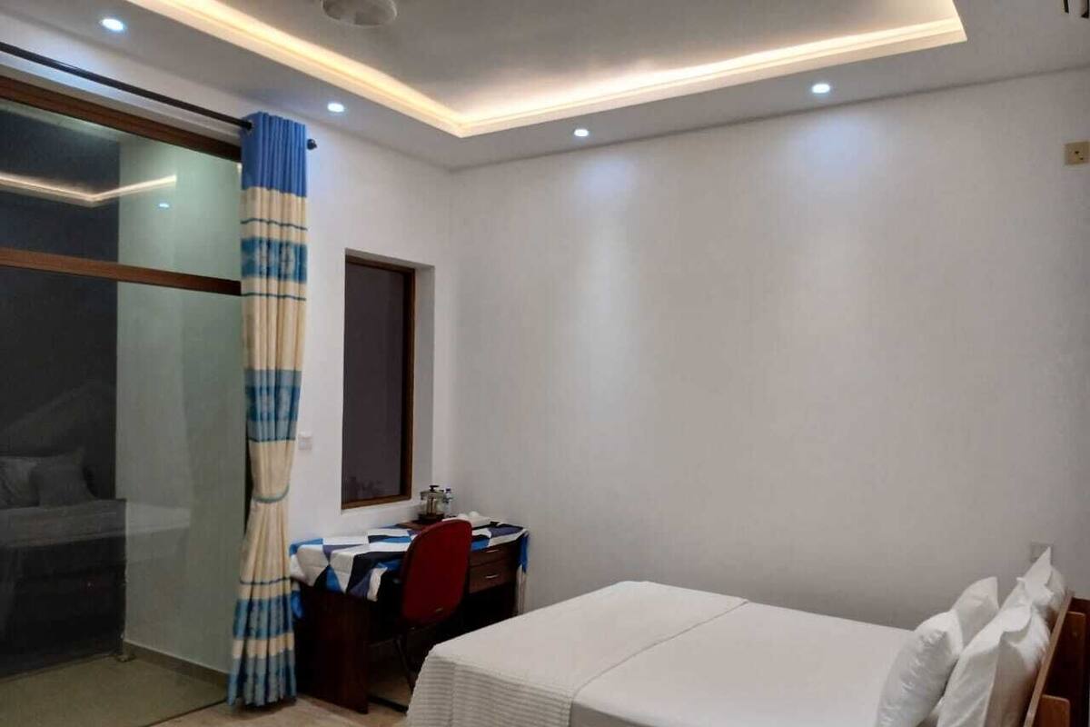 Un dormitorio con cama, escritorio y silla.