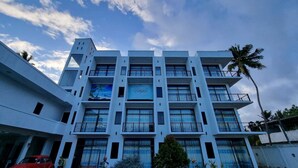 A multi-story hotel with a modern design, featuring balconies with decorative railings, large windows, and a prominent sign. - Utopia Polhena Hotel (Matara)