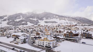 Un pueblo cubierto de nieve con una mezcla de edificios tradicionales y modernos, incluyendo un hotel destacado con un letrero grande.