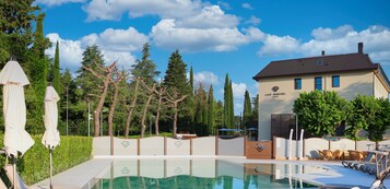 季节性开放的室外游泳池，10:00 至 19:00 开放，池畔遮阳伞，日光浴躺椅