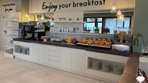 A breakfast buffet with a sign that reads "Enjoy your breakfast."