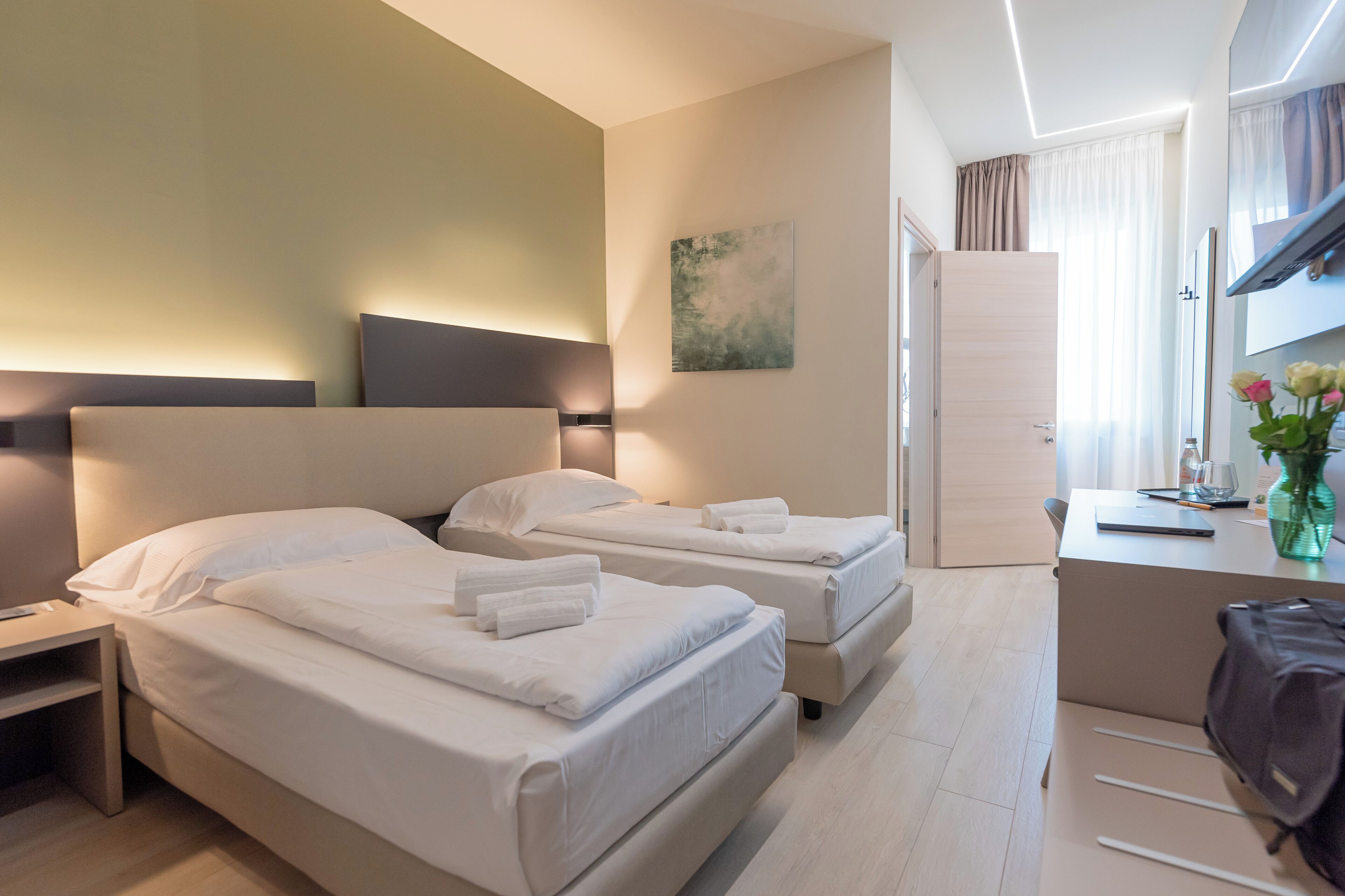 Una habitación de hotel con dos camas, un escritorio y una silla.