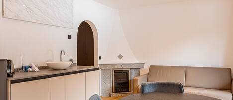 A modern kitchen with a white marble backsplash, a built-in oven, and a round dining table with chairs.