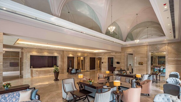 A spacious lobby with a high ceiling, marble flooring, and a mix of seating arrangements including sofas and armchairs. - Park Plaza Jalandhar (Jalandhar)