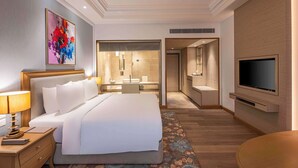 A modern hotel room with a large bed, a desk, a television, and a bathroom visible through an open door. - Park Plaza Jalandhar (Jalandhar)