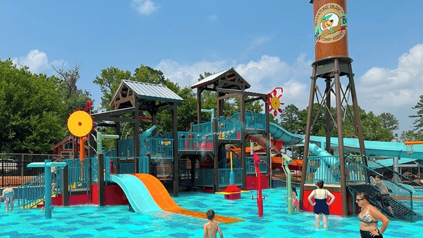 Un parc aquatique doté d’une aire de jeux, de toboggans et d’une tour d’eau.