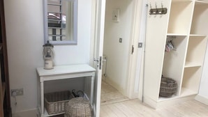 Ein Zimmer mit einer weißen Kommode, Korbwannen, einem hängenden Laternen und einer weißen Regaleinheit mit Wannen.