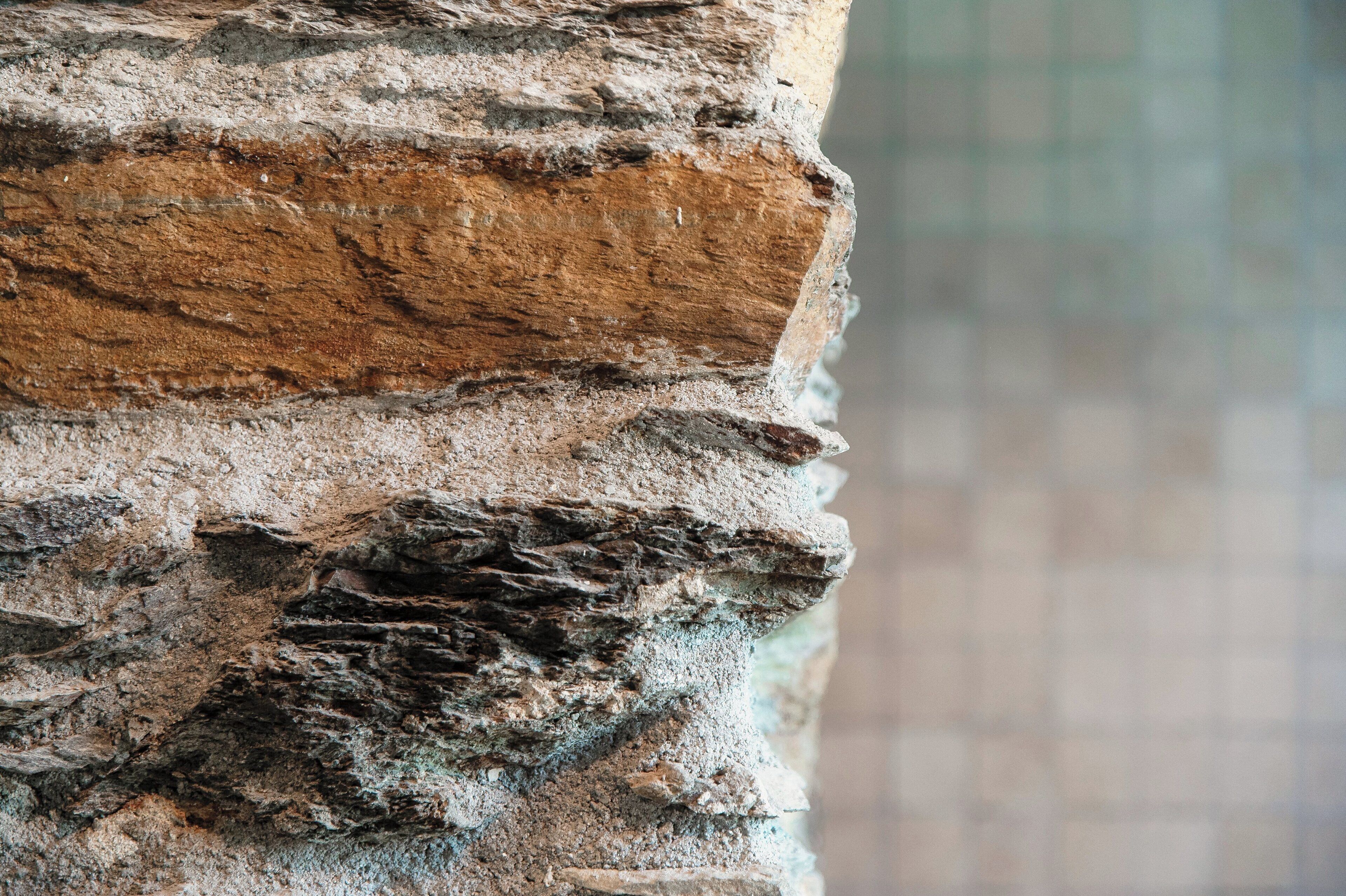 A close-up of a brick wall with a rough texture and visible mortar lines.