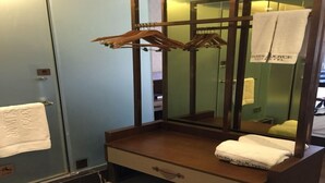 Een badkamer met een houten wastafelmeubel, een spiegel en een handdoekrek.