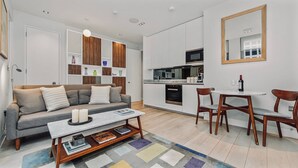 A modern apartment with a living area, kitchenette, and dining space.