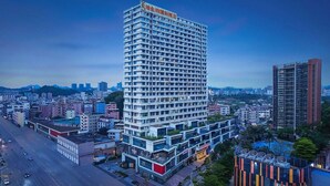 Un hotel alt amb nombrosos pisos, un rètol destacat al capdamunt i vista de l'entorn urbà.