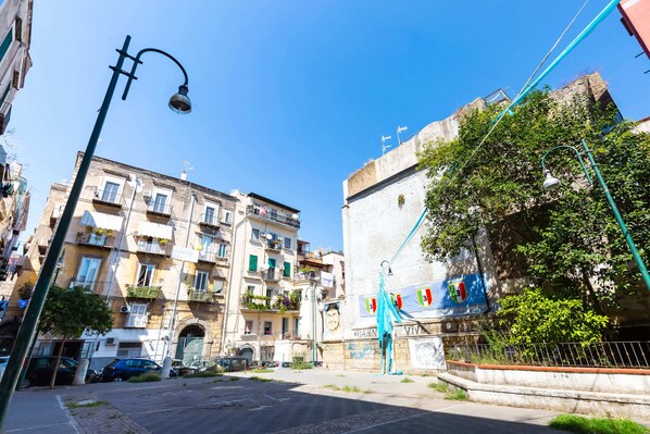 A street view with buildings, a street lamp, and a flag. - Starguest Duomo  (Naples)