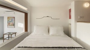 A bedroom with a bed, a wooden nightstand, a painting, and a wall-mounted light fixture. - Central Athenian Penthouse Acropolis (Athens)