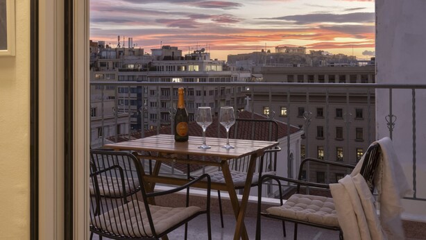 A balcony with a table set for two, a bottle of champagne, and two wine glasses. - Central Athenian Penthouse Acropolis (Athens)
