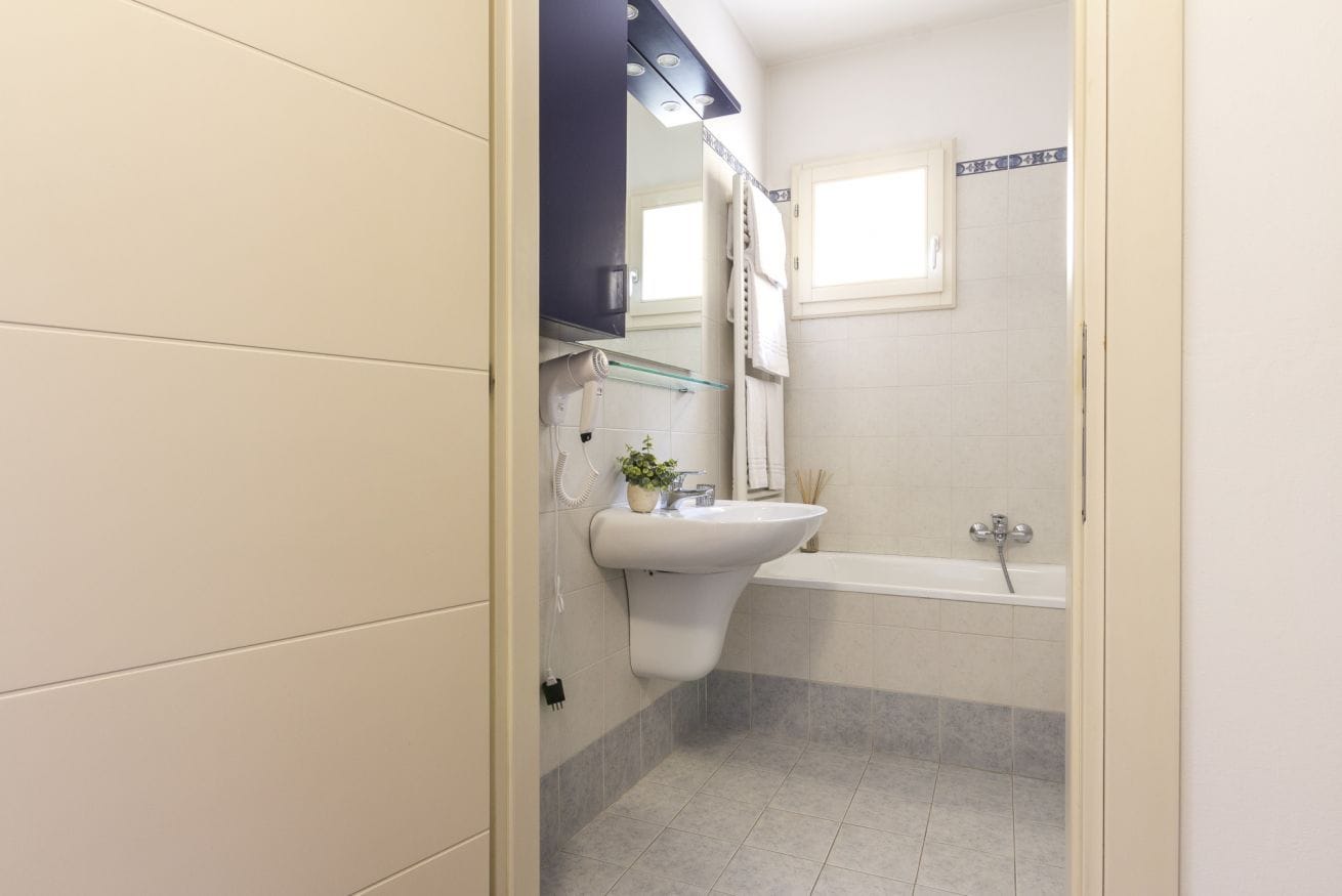 Ein Badezimmer mit Waschbecken, Spiegel und Badewanne.