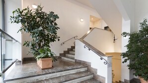 A staircase with marble steps, a potted plant, and a handrail. - Casa Margarita, elegant house with parking (Firenze)