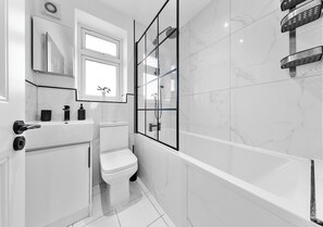 Un baño moderno con inodoro, lavabo y ducha.