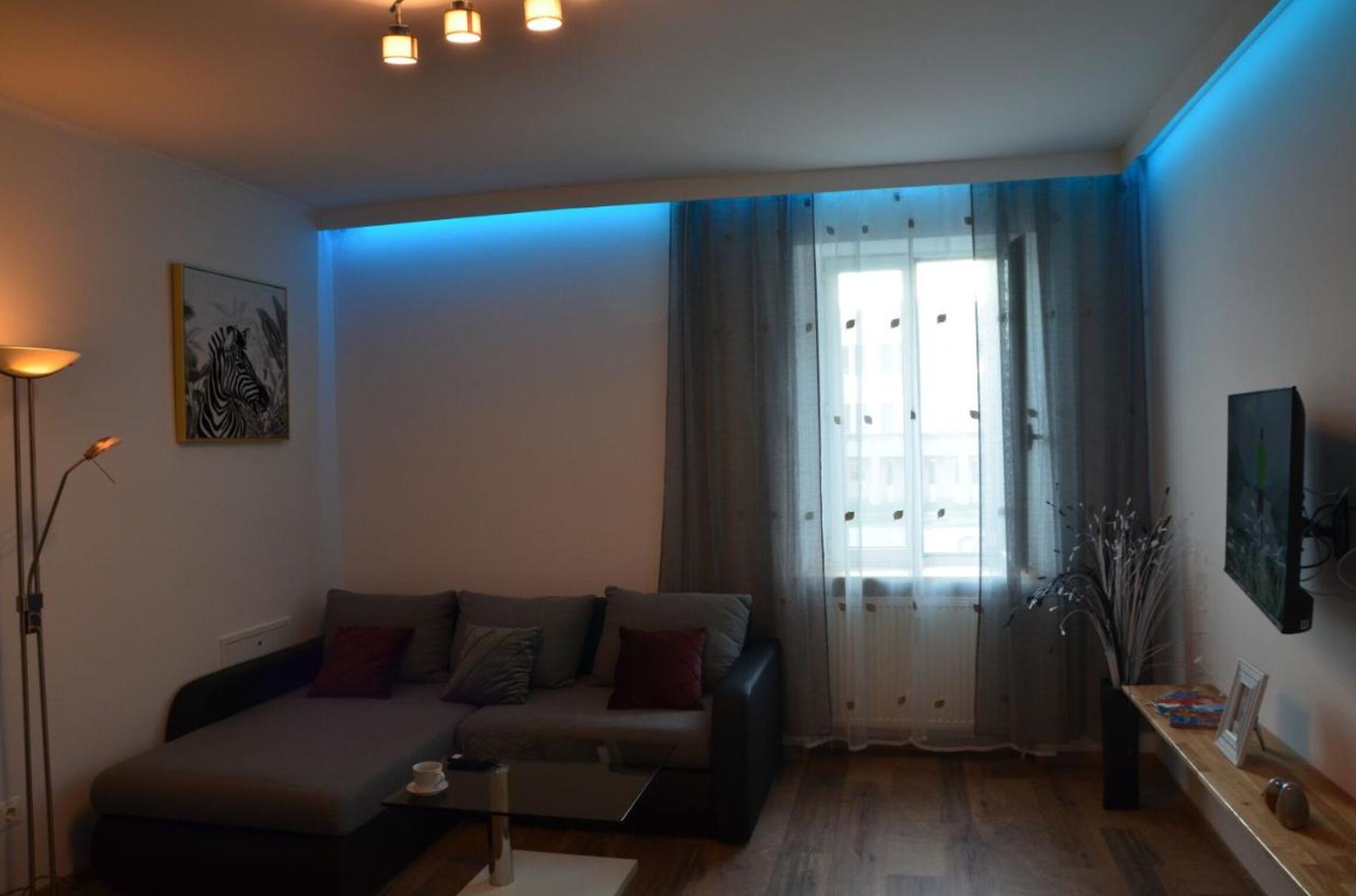 Un salon moderne avec un canapé, une table basse et un lampadaire.