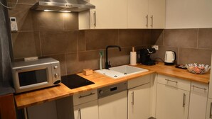 A modern kitchen with a microwave, sink, and stove. - Vega - Free Parking - Self Checkin (Graz)