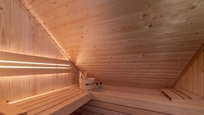 Un sauna en bois avec des bancs et un mur en bois.
