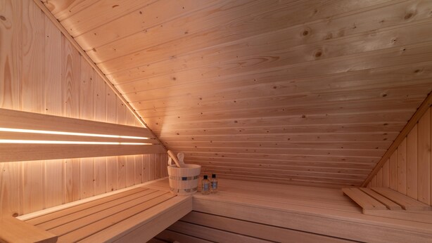 Eine Holzsauna mit Bänken und einer Holzwand.