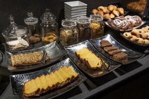 A buffet with various food items including pastries, breads, and desserts. - Vigo Center Rooms (Vigo)