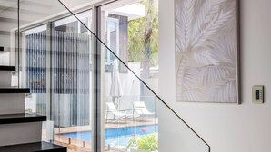 Un intérieur moderne avec un escalier en verre menant à un espace piscine.