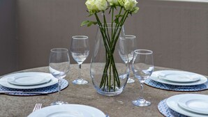 Una mesa lista para comer con vistas al océano y montañas al fondo.