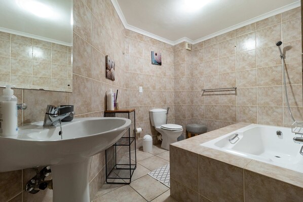A bathroom with a sink, toilet, and bathtub. - 3 Bedroom Family Apartment Beach Club - Houtbay (Cape Town)