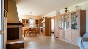 A spacious kitchen with wooden cabinets, a dining area, and a built-in oven.