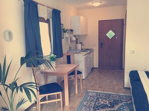 Cozy living space with a kitchenette, dining table, and comfortable seating for two.