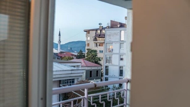 Vista desde un balcón con barandilla, sobre una zona residencial con edificios y una mezquita.